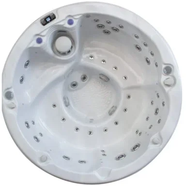 Bain à remous circulaire blanc avec jets et commandes intégrés.
